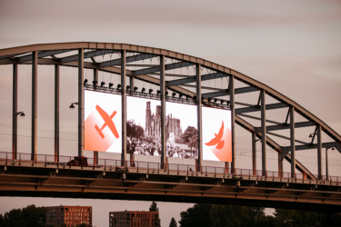 Four LED screens hanging between bridge pilars